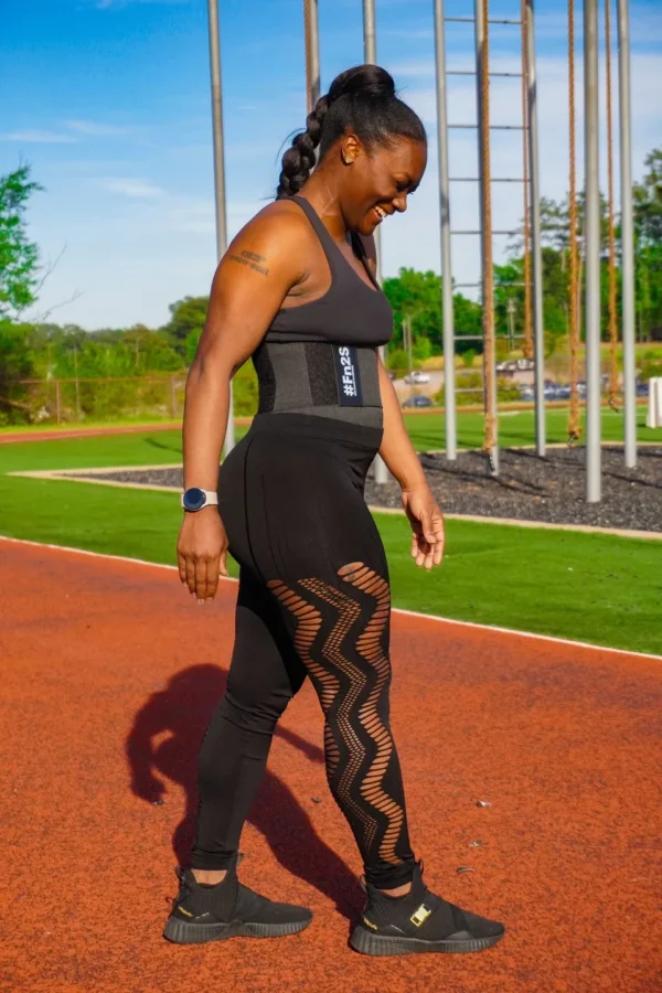 A woman in black outfit walking on track.