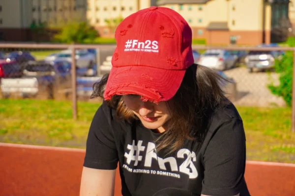 A woman wearing a red hat and black shirt.