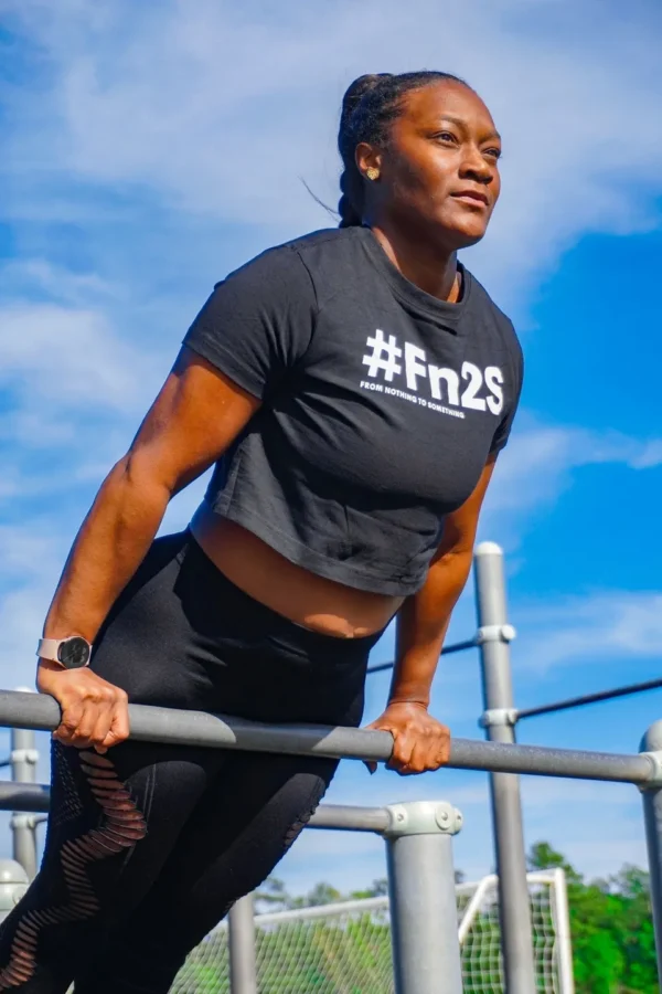 A woman is doing pull ups on the bars