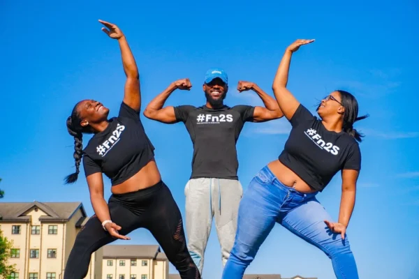 A man and two women are posing for the camera.