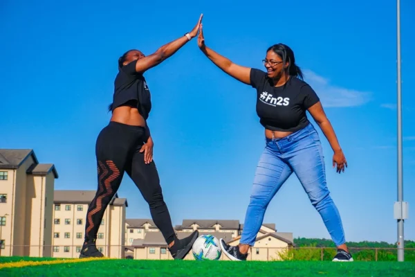 Two women giving each other a high five.