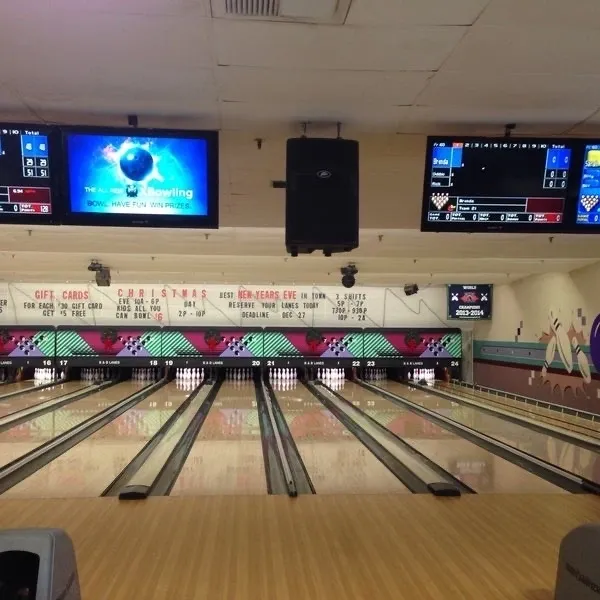 A bowling alley with several lanes and a television.